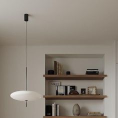 a living room filled with lots of furniture and books on top of wooden shelving