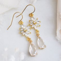 "Flower Earring // Floral Earrings // Bridesmaids Earrings // Boho Bridal Earrings // Whimsical Earrings // Floral Drop Earrings // 14k Gold Filled Earrings These beautiful whimsical earrings are created with a unique cubic zirconia floral design. Secured to them are clear faceted glass teardrops. The flower earrings are secured to dainty 14k gold filled earring wires for a comfortable all day wear. Whether searching for boho bridal earrings for your bridesmaids or unique floral earrings for your wedding day, all of my jewelry arrives suitably gift wrapped ready for gift giving. Measurements: The length of the dainty flower earrings hang a little over 1.5\" long Metals: 14k gold filled earring hooks 14k gold filled jump rings Gold plated cubic zirconia Gold plated teardrops Complete the lo