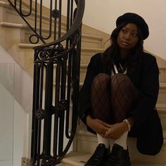 a woman sitting on the stairs with her legs crossed