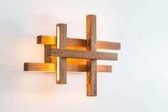 a wall light made out of wood with two lights on each side and one in the middle