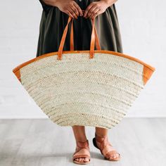 This oversized tote bag will take you everywhere you need to go! Woven with reeds and finished with attractive and durable leather accents and straps, the Rosemerra Handwoven Basket Tote has enough room for all of your essentials for a day at the beach, pool, park, and beyond. Exact size and shape will vary. Handcrafted by artisans with OTICART in Kenya. Chain Scarf, Candle Wall Decor, Basket Tote, Oversized Tote Bag, Hand Woven Baskets, Oversized Tote, Leather Accents, Accessories Bags Purses, Scarf Hat