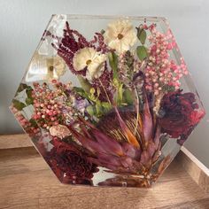 a glass vase with flowers in it sitting on a table