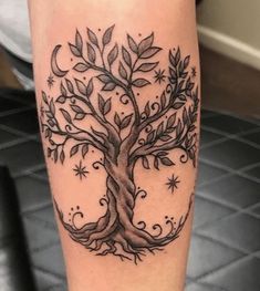 a black and white tree tattoo on the leg