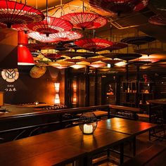 an empty restaurant with umbrellas hanging from the ceiling