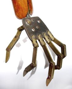 a metal hand holding a wooden object on it's back