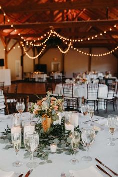 the tables are set with white linens, silverware and floral centerpieces