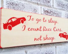 a sign on the side of a brick building that says to go to sleep, i can't race cars not sheep