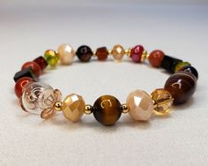 "The bracelet is made of crystals, glass, and gemstones and is beautifully handcrafted. Featuring vibrant crystal beads, black onyx square beads, ceramic beads, yellow tiger eye, agate stone, and 14 kt gold plated accent beads. With its versatile bead assortment, this bracelet goes with any outfit. You will be able to show off your unique style and make your wrist the center of attention. Most of my bracelets fit wrists between 6\" and 6.5\" in size. Before placing an order, please confirm your size. Thank you" Elegant Beaded Bracelets With Natural Stones And Czech Glass, Elegant Czech Glass Crystal Bracelet With Faceted Beads, Elegant Agate Beaded Bracelet With Colorful Beads, Onyx Beaded Stretch Bracelet Gift, Elegant Beaded Agate Crystal Bracelet, Elegant Adjustable Glass Crystal Bracelet, Elegant Glass Beaded Bracelets With Spacer Beads, Elegant Beaded Agate Bracelets, Brown Crystal Faceted Beads Bracelet