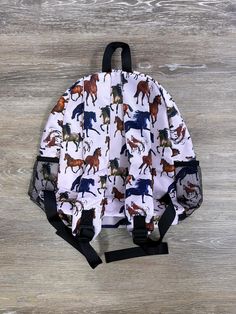 Gallop into style with our Just Horsing Around Kids' School Backpack. Adorned with colorful horse designs, this backpack offers ample storage for books, supplies, and more. Perfect for school and adventures, it combines durability and charm, ensuring your child stays organized and trendy. Ideal for horse-loving kids. Shop now for this fun and functional backpack! Features of Our Just Horsing Around Kids' Backpack Perfect size for adults or kids. Inside zipper pocket. Front pocket. Side pockets. Inside open pockets. Adjustable straps. INCLUDES: Backpack AVAILABILITY: Ready to Ship We Ship from Ohio Adjustable Multicolor Backpack For School, Adjustable Multicolor School Backpack, Adjustable Backpack For Daily Use And Back To School, Adjustable Standard Backpack For Back To School, Adjustable Backpack For End Of School Year, Adjustable Standard School Backpack, Adjustable Backpack For Back To School, Kids School Backpack, Book Storage