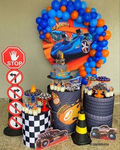 a birthday party with balloons, decorations and cars on the counter top in front of a stop sign