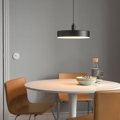 a white table with four chairs around it and a bottle of water on the other side