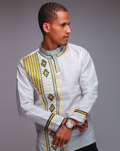 Tsedey embroidered Shirt is an all-season garment symbolizing the spring season in Ethiopia, made by hand and designed with a strong spirit of tradition. The extraordinary collar to abdomen ‘tilf’ pattern imitates the sun setting, highlighting the African light. Wearable for any season and weather condition, this 100% handmade shirt has long vertical ‘tilf’ with the color combination of Yellow and Silver. ❶ MEASUREMENTS Size (Inches) S M L XL Chest 44 47 50 53 Length 28 29 30 31 Shoulder 19 20 2 Handmade Shirts, Sun Setting, Spring Season, Embroidered Shirt, Modern Fashion, White Fabrics, Color Combination, Ethiopia, Color Combinations