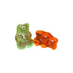 two gummy bears sitting next to each other on a white surface, one is orange and the other is green