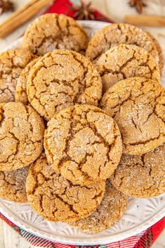 a plate full of ginger cookies with cinnamon sticks in the background