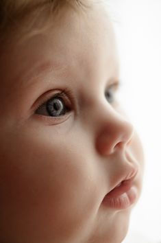 a close up of a baby's face with blue eyes