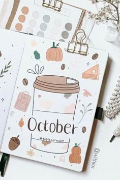 an open notebook with the words october written on it, surrounded by fall themed items