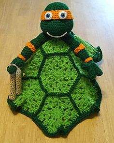 a crocheted turtle sitting on top of a wooden floor