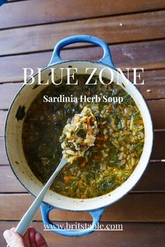 a person holding a ladle full of soup on a wooden table with the words blue zone above it