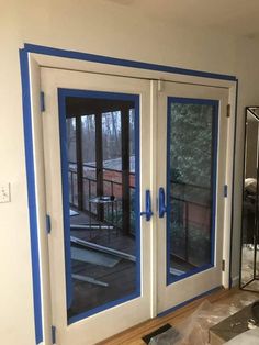 the inside of a house with double doors painted white and blue on the outside wall