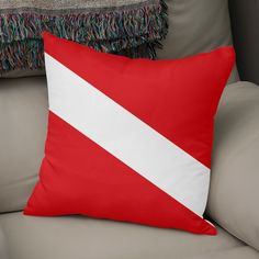 a red and white pillow sitting on top of a couch