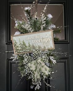 a wreath on the front door with a sign that says where the trees are taken