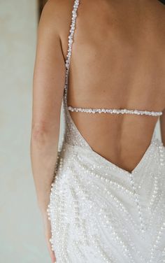 the back of a woman's dress with pearls on it