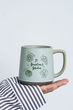 a person holding a coffee mug with the words, because it's green on it