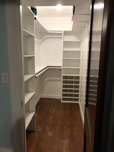 an empty walk - in closet with shelves and shelving units on the wall, along with hard wood flooring