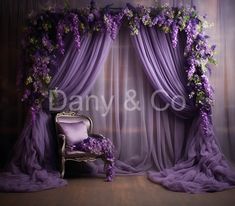 a chair sitting in front of a purple drapes with flowers on the back and curtains behind it