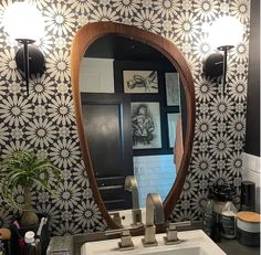 a bathroom sink sitting under a large mirror next to a wall mounted faucet