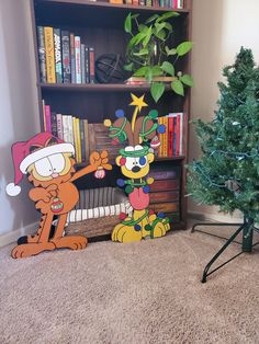 a christmas tree and some cartoon characters in front of a bookshelf