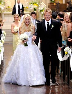 a bride and groom are walking down the aisle