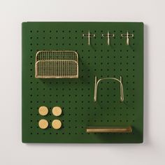 a green peg board with some metal items on it