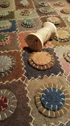 a spool of thread sitting on top of a rug covered in different colored circles