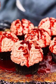 some cupcakes with red icing on a plate