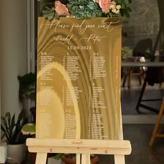 a wooden easel with a sign and flowers on it