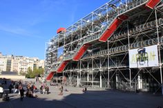 a large building with scaffolding on the side and people walking around outside it