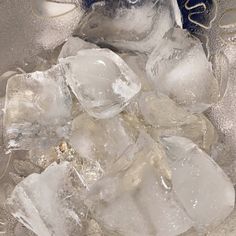 ice cubes are sitting on top of an ice bucket filled with water and ice