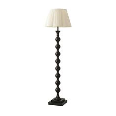 a black lamp with a white shade on it's base and a beige lampshade