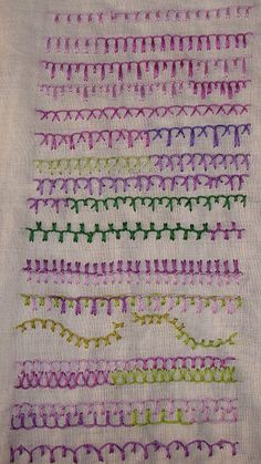 a close up of a piece of cloth with different colored stitchs on the side