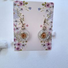 Original earrings with a fir flower and moss embedded in resin on a white background. A spacer with cubic zirconia adds charm to the decoration Stainless steel, open hooks. Diameter 18mm Total length 30mm I cordially invite you. #handmade #handmade #flowers #epoxy #art #jewelry #vinted #idea #gift #resin #earrings #etsi Elegant White Earrings With Pressed Flowers, White Pressed Flower Earrings For Wedding, White Flower Earrings With Pressed Flowers For Wedding, White Hypoallergenic Nature-inspired Earrings, Nature-inspired Hypoallergenic White Earrings, Hypoallergenic White Nature-inspired Earrings, Handmade Resin Flower Earrings, Elegant Resin Earrings With Pressed Flowers, Unique Flower-shaped Resin Earrings