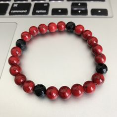 Red Jade And Black Faceted Onyx 8mm Beaded Bracelet Embody the color of strength and resolution with this Red Jade bracelet. Accented with four faceted glossy onyx beads.This piece is designed to be stacked with other like Embody'd art pieces. Great for any casual occasion or event. This bracelet is crafted with quality elastic stretch cord. This bracelet is also designed to fit snug on the wrist. Laced 4 times to ensure maximum strength and hold. Most bracelets are made large unless specified o Red Stretch Bracelet With 8mm Round Beads, Red Bracelet With 8mm Round Beads, Red Stretch Bracelet With Black Beads As A Gift, Red Bracelets With Black Round Beads, Red Stretch Bracelet With Black Beads, Red Stretch Bracelet With 8mm Beads, Red Crystal Bracelet With 8mm Beads, Casual Red Wristband With Round Beads, Red Jade Bracelet