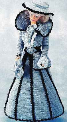 a crocheted doll wearing a dress and hat