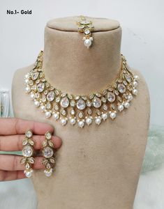 *Light Weight Kundan necklace set with earrings and tikka. *Studded with kundan stone. *Light Weight Gold kundan necklace. No.1-  *Necklace width- 1.6 inches (included pearl drop) *Earrings Length- 2.2 inches(included pearl drop) *Earrings width- 0.6 inches No.2-  *Necklace width- 0.9 inches (included pearl drop) *Earrings Length- 2.5 inches(included pearl drop) *Earrings width- 0.9 inches No.3-  *Necklace width- 1.1 inches (included pearl drop) *Earrings Length- 1.9 inches(included pearl drop) White Kundan Bridal Necklace For Celebration, White Kundan Round Necklaces, Bollywood Style White Bridal Necklace For Party, White Kundan Necklace With Hand Set Details, White Kundan Necklaces For Celebration, Hand Set White Kundan Necklace, White Kundan Jewelry Sets, White Stone Work Necklace For Celebration, White Stone Work Necklaces For Celebration