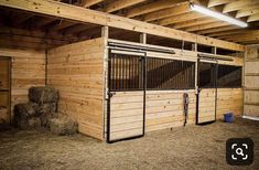 the inside of a barn with hay and stalls