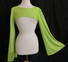 This shrug is made of neon green jersey micro mesh stretch fabric.  This fabric is soft stretchy and very breathable, making it ideal for outdoor summer festival wear. The shrug has fingertip length flared bell sleeves. It fits above the bust in the front.  Small fits a bust of 30" to 33", medium fits a bust of 33" to 36". Small and Medium sleeves measure 17" around bicep area. Large fits a bust of 36" to 39",  XLarge fits a bust of 39" to 42" . Large and Xlarge sleeves measure 18" around bicep area. Sleeve length from shoulder to hem is 28". Down center back measures 11&1/2". Fitted Long Sleeve Rave Top, Stretch Bell Sleeve Tops For Party, Fitted Rave Tops For Halloween, Stretch Tops For Halloween Cosplay, Fitted Rave Top For Cosplay, Rave Style Fitted Top For Cosplay, Stretch Tops For Costume Party In Fall, Stretch Tops For Fall Costume Party, Fitted Winter Tops For Cosplay