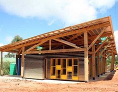 a wooden structure sitting on top of a dirt field next to a building under construction