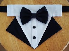 a black and white tuxedo with a bow tie sitting on top of a wooden table