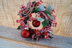 a red and white christmas ornament on a wooden table with burlocks