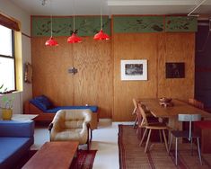 a living room with wood paneling and blue couches next to a wooden table